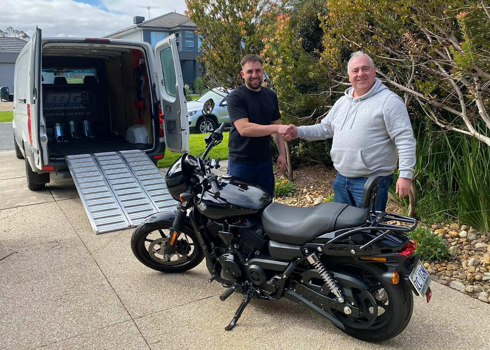 Customer motorcycle handover beside the Motorcycle Transport Melbourne van
